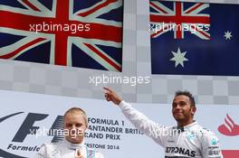 Race winner Lewis Hamilton (GBR) Mercedes AMG F1 (Right) celebrates on the podium. 06.07.2014. Formula 1 World Championship, Rd 9, British Grand Prix, Silverstone, England, Race Day.