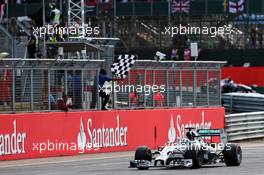 Race winner Lewis Hamilton (GBR) Mercedes AMG F1 W05 takes the chequered flag at the end of the race. 06.07.2014. Formula 1 World Championship, Rd 9, British Grand Prix, Silverstone, England, Race Day.