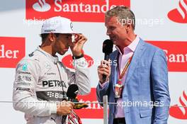 Race winner Lewis Hamilton (GBR) Mercedes AMG F1 on the podium with David Coulthard (GBR) Red Bull Racing and Scuderia Toro Advisor / BBC Television Commentator. 06.07.2014. Formula 1 World Championship, Rd 9, British Grand Prix, Silverstone, England, Race Day.
