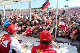 (L to R): Fernando Alonso (ESP) Ferrari and team mate Kimi Raikkonen (FIN) Ferrari sign autographs for the fans. 24.07.2014. Formula 1 World Championship, Rd 11, Hungarian Grand Prix, Budapest, Hungary, Preparation Day.