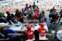 (L to R): Fernando Alonso (ESP) Ferrari and team mate Kimi Raikkonen (FIN) Ferrari sign autographs for the fans at the Fanzone. 09.10.2014. Formula 1 World Championship, Rd 16, Russian Grand Prix, Sochi Autodrom, Sochi, Russia, Preparation Day.