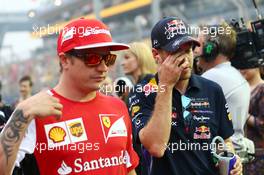 (L to R): Kimi Raikkonen (FIN) Ferrari and Sebastian Vettel (GER) Red Bull Racing on the drivers parade. 21.09.2014. Formula 1 World Championship, Rd 14, Singapore Grand Prix, Singapore, Singapore, Race Day.