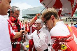 (L to R): Maurizio Arrivabene (ITA) Ferrari Team Principal with Bernie Ecclestone (GBR) and Sebastian Vettel (GER) Ferrari on the grid. 15.11.2015. Formula 1 World Championship, Rd 18, Brazilian Grand Prix, Sao Paulo, Brazil, Race Day.