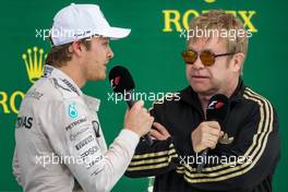 (L to R): Second placed Nico Rosberg (GER) Mercedes AMG F1 on the podium with Sir Elton John (GBR). 25.10.2015. Formula 1 World Championship, Rd 16, United States Grand Prix, Austin, Texas, USA, Race Day.