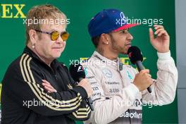 (L to R): Sir Elton John (GBR) on the podium with race winner and World Champion Lewis Hamilton (GBR) Mercedes AMG F1. 25.10.2015. Formula 1 World Championship, Rd 16, United States Grand Prix, Austin, Texas, USA, Race Day.