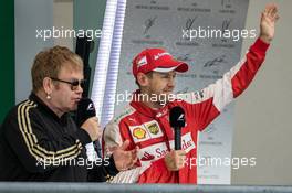 Sebastian Vettel (GER) Ferrari celebrates his third position on the podium with Sir Elton John (GBR). 25.10.2015. Formula 1 World Championship, Rd 16, United States Grand Prix, Austin, Texas, USA, Race Day.