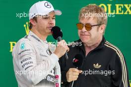 (L to R): Second placed Nico Rosberg (GER) Mercedes AMG F1 on the podium with Sir Elton John (GBR). 25.10.2015. Formula 1 World Championship, Rd 16, United States Grand Prix, Austin, Texas, USA, Race Day.