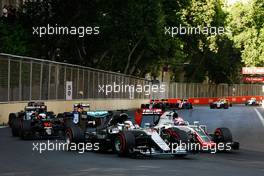 Lewis Hamilton (GBR) Mercedes AMG F1 W07 Hybrid and Romain Grosjean (FRA) Haas F1 Team VF-16 battle for position. 19.06.2016. Formula 1 World Championship, Rd 8, European Grand Prix, Baku Street Circuit, Azerbaijan, Race Day.
