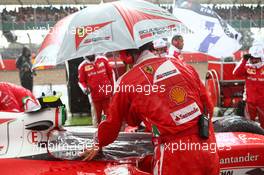 A Ferrari mechanic keeping the rain out of the cock pit. 10.07.2016. Formula 1 World Championship, Rd 10, British Grand Prix, Silverstone, England, Race Day.