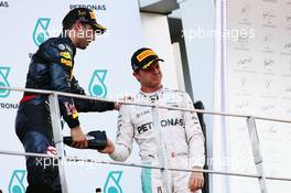 Third placed Nico Rosberg (GER) Mercedes AMG F1 celebrates on the podium by drinking champagne from the race boot of race winner Daniel Ricciardo (AUS) Red Bull Racing. 02.10.2016. Formula 1 World Championship, Rd 16, Malaysian Grand Prix, Sepang, Malaysia, Sunday.