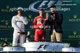 (L to R): Lewis Hamilton (GBR) Mercedes AMG F1 with Sebastian Vettel (GER) Ferrari and Mark Webber (AUS) Channel 4 Presenter on the podium. 26.03.2017. Formula 1 World Championship, Rd 1, Australian Grand Prix, Albert Park, Melbourne, Australia, Race Day.