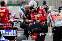 Sebastian Vettel (GER) Ferrari tries to look at the Red Bull Racing RB13 iin qualifying parc ferme. 25.03.2017. Formula 1 World Championship, Rd 1, Australian Grand Prix, Albert Park, Melbourne, Australia, Qualifying Day.