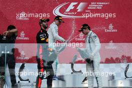 (L to R): Race winner Daniel Ricciardo (AUS) Red Bull Racing celebrates with the champagne on the podium with Valtteri Bottas (FIN) Mercedes AMG F1 and Lance Stroll (CDN) Williams. 25.06.2017. Formula 1 World Championship, Rd 8, Azerbaijan Grand Prix, Baku Street Circuit, Azerbaijan, Race Day.