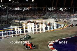 Sebastian Vettel (GER) Ferrari SF70H and Lewis Hamilton (GBR) Mercedes AMG F1 W08 leads at the start of the race as Kimi Raikkonen (FIN) Ferrari SF70H, Max Verstappen (NLD) Red Bull Racing RB13 and Fernando Alonso (ESP) McLaren MCL32, crash.                                17.09.2017. Formula 1 World Championship, Rd 14, Singapore Grand Prix, Marina Bay Street Circuit, Singapore, Race Day.